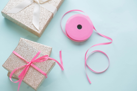 Blue gift box and silver Christmas ball and ribbon on pink canvas backgroundの写真素材