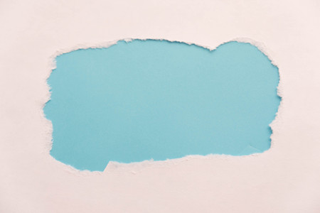 Breakthrough paper hole with blue background, isolated on white.の写真素材