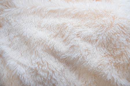 a soft white, plush micro fleece fabric blanket is swirled into a circular pattern backgroundの写真素材