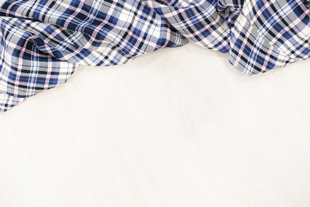 Flat lay of scarf with Christmas tartan texture and branch of tree on wooden background with space in middle - Christmas or New Year backgroundの写真素材