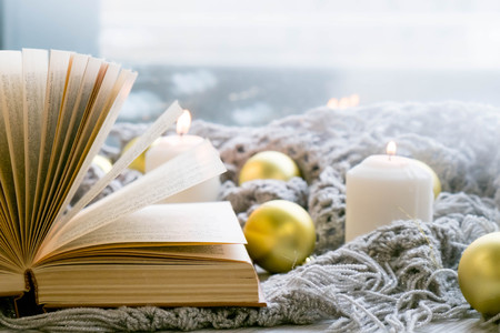 Interior of room with cozy window sill, cup of tea, books, candels, homely comfy rest conceptの写真素材