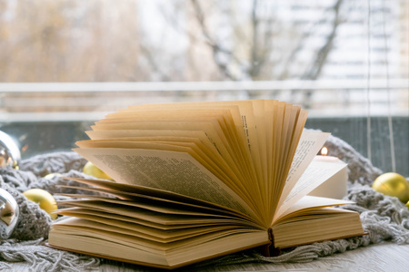 Interior of room with cozy window sill, cup of tea, books, candels, homely comfy rest conceptの写真素材