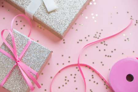 Blue gift box and silver Christmas ball and ribbon on pink canvas backgroundの写真素材