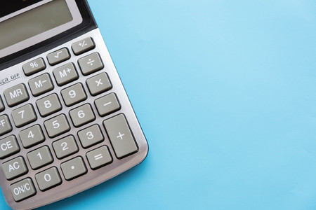 Office desk table with calculator. Top view with copy space. blue backgroundの写真素材