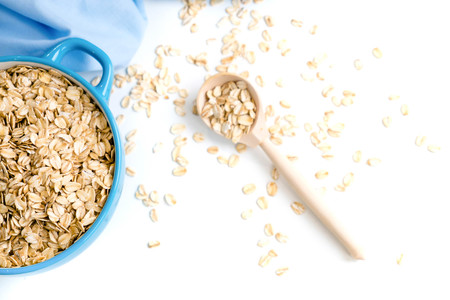 Oat flakes plate with milk, orange, eggs on a wooden white table. Top view of healthy oat flakes breakfast. Copy space. blue napkin Breakfast in bed plate, breakfast table buffet. Healthy ingredientsの写真素材