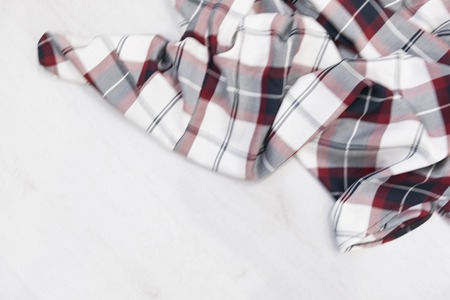 Flat lay of scarf with Christmas tartan texture and branch of tree on wooden background with space in middle - Christmas or New Year backgroundの写真素材