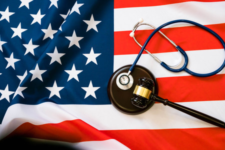 Gavel and stethoscope on national flag of USA. Forensic medicine conceptの写真素材