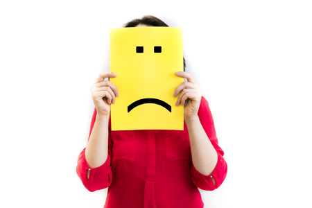 Put a sad pessimistic face on, sadness and depressive emotions concept, man holding picture frame with smiley emoticon printed.の写真素材
