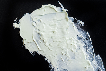 Smear clay mask for face and body. texture is smeared isolated on a black background. natural products smear paint of mud cosmetic from clay careの写真素材