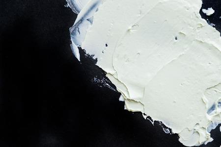 Smear clay mask for face and body. texture is smeared isolated on a black background. natural products smear paint of mud cosmetic from clay careの写真素材