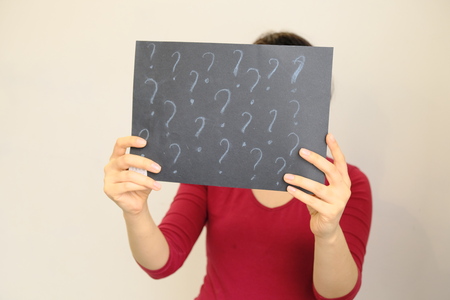 anonymous, hiding his face behind the plate. woman showing a wooden frame, place for text.copy space.の写真素材