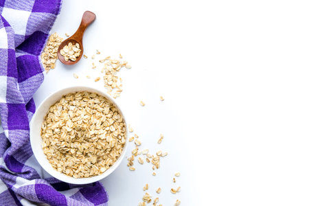 Rolled oats on white wooden background