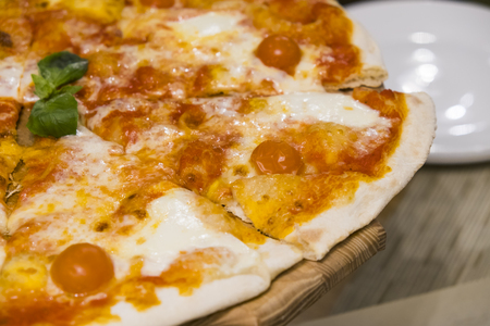 Food. Pizza with tomato, salami and olives. Pizza with ham, pepper and olives. Delicious fresh pizza served on wooden table.の写真素材