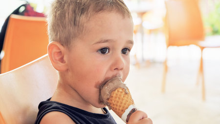 Cute kid having chocolate ice cream. two year old childの写真素材