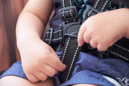 safety belt in the baby stroller, a small child tries to undo the lock
