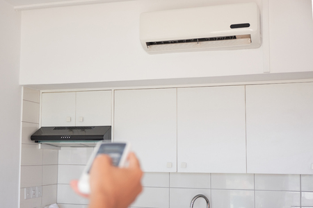 Hand of the woman turning on air conditioningの写真素材