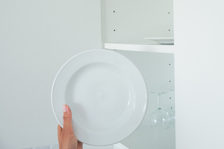 Cropped image of attractive young woman is washing dishes while doing cleaning at homeの写真素材