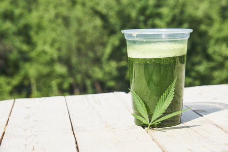 Healthy cannabis smoothie on wooden background. Natural supplement, detox and healthy living.の写真素材