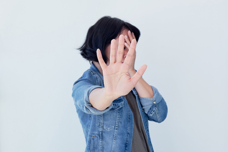 Closeup portrait young annoyed angry woman with bad attitude giving talk to hand gesture with palm outward isolated grey wall background. Negative human emotion face expression feeling body languageの写真素材