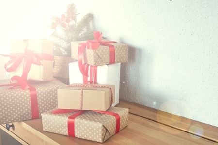 many Christmas presents on a table in the background a Christmas treeの写真素材