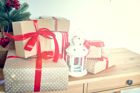 many Christmas presents on a table in the background a Christmas treeの写真素材