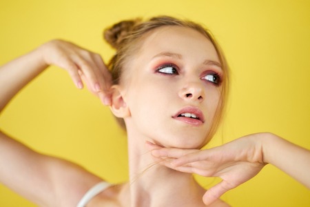 young girl on a yellow bright background. beautiful makeup, bright image, place for textの写真素材