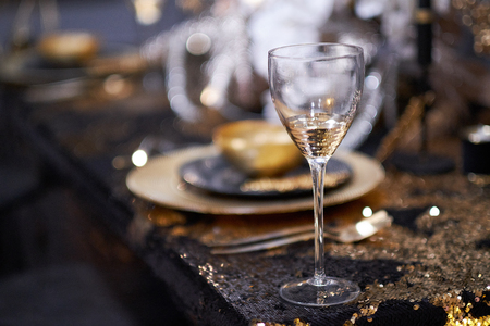 Christmas table setting with plates, silverware, gift box and decorations in black and gold colorsの写真素材