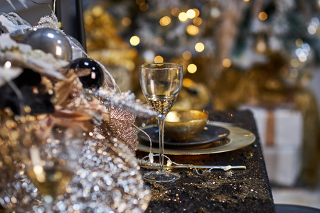 Christmas table setting with plates, silverware, gift box and decorations in black and gold colorsの写真素材