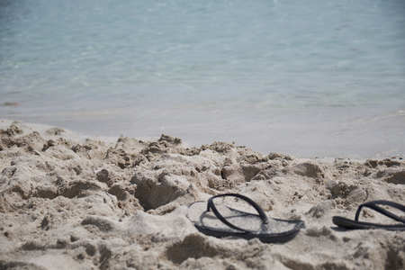 black flip-flops on the beachの写真素材