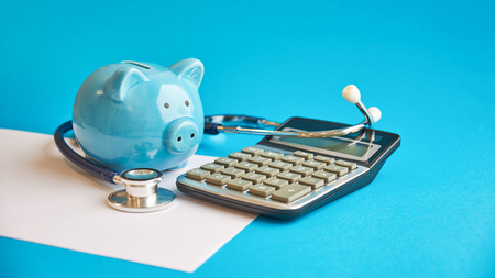 Piggy bank with stethoscope isolated on blue background. concept of financial literacy. Creating and maintaining a budget. keeping their finances on track. ruin loan historyの写真素材