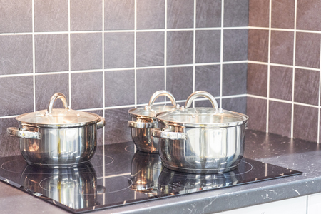 Stainless steel pot on electric stove with kitchen timer in modern kitchen. Cooking utensils conceptの写真素材