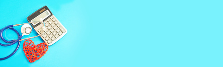 red heart and calculator with stethoscope isolated on blue background. tax offset concept. Medical Expense Deductions and Tax Breaks. affordable care act. high cost health careの写真素材
