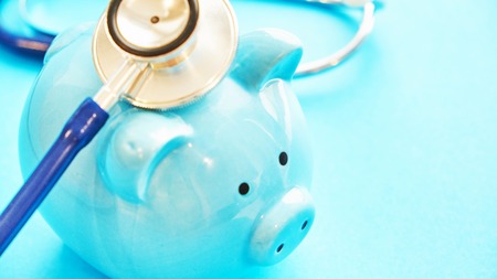 piggy bank and stethoscope on blue background, concept of medical expenses. bankrupt resuscitationの写真素材