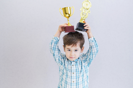 funny boy age three years old, holding in holding a trophyの写真素材