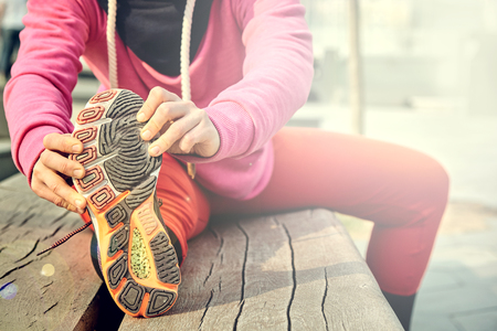 Smiling fit woman relaxing her leg muscles.の写真素材