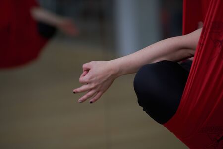 Adult woman practices aero anti-gravity yoga position in studio. Inversion bow pose in aero anti gravity yoga. Aerial exercisesの写真素材