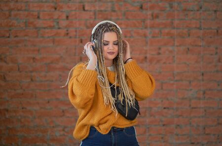 Fashion pretty cool girl in headphones listening to music.の写真素材