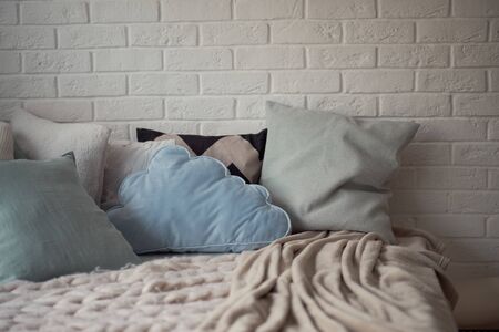 cozy children's room in bright soft colors, pillows and a blanket are lying on the bed.の写真素材