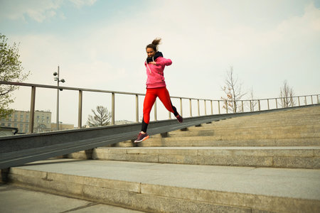 healthy lifestyle sports woman running up on stone stairs at sunrise seaside