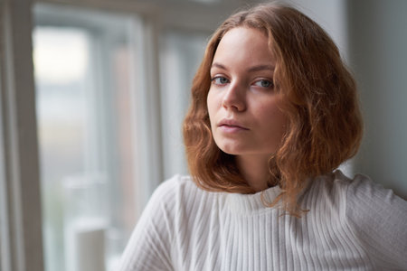 portrait of a beautiful curly girl. the mysterious face of a woman at the window.