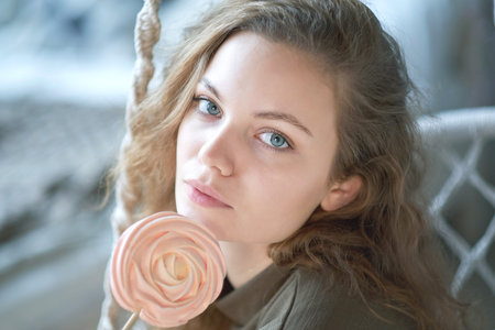 pretty young woman eating candies at home on the bed