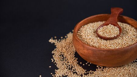 White quinoa seeds on a black background. quinoa on kitchen table top view. Healthy and diet superfood product.の写真素材