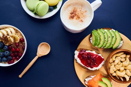 breakfast top view black background. oatmeal with berries, toasts on a wooden tray, nuts, coffee.の写真素材