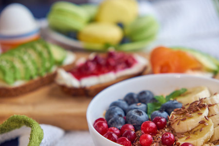 breakfast top view black background. oatmeal with berries, toasts on a wooden tray, nuts, coffee.の写真素材
