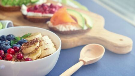 breakfast top view black background. oatmeal with berries, toasts on a wooden tray, nuts, coffee.の写真素材