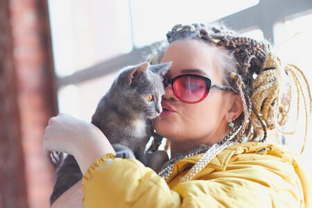 portrait of an eccentric modern young woman, bright make-up sunglasses, and a crazy hairstyle.の写真素材