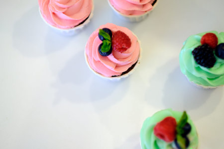 top view of set of arranged cupcakes with frosting isolated on white