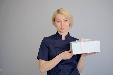 Portrait of a young female cook over dark background.の写真素材