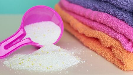 pink plastic measuring vessel with washing powder, containers with detergent, stack terry towelsの写真素材