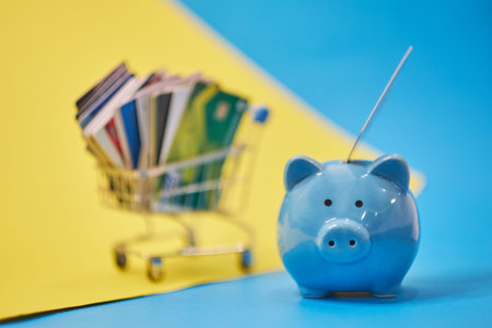 piggy bank and Pile of credit cards , financial waste. Debt restructuring, financial distress, renegotiate its delinquent debts.. stack of bright colorful discount plastic cardsの写真素材